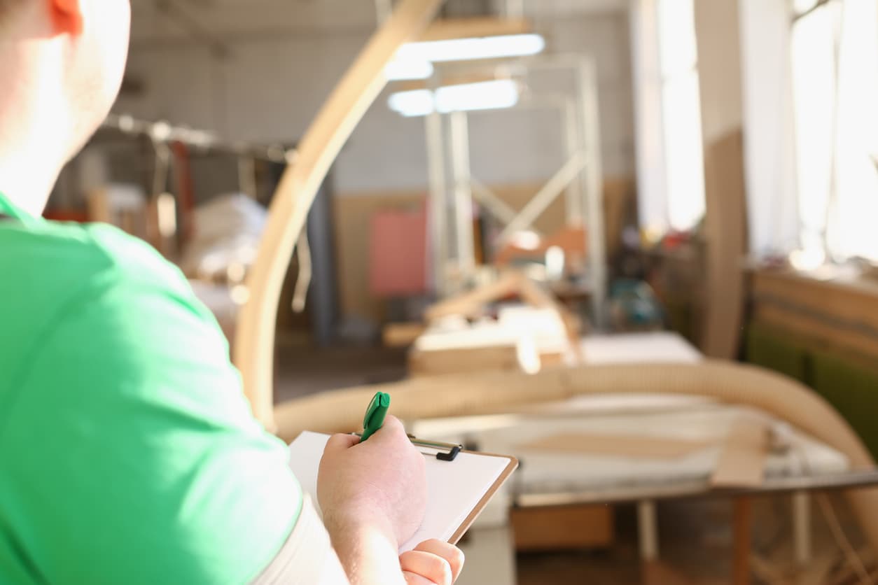 Inspector reviewing Hotel Furniture Quality Checklist Before Shipment at a factory loading bay