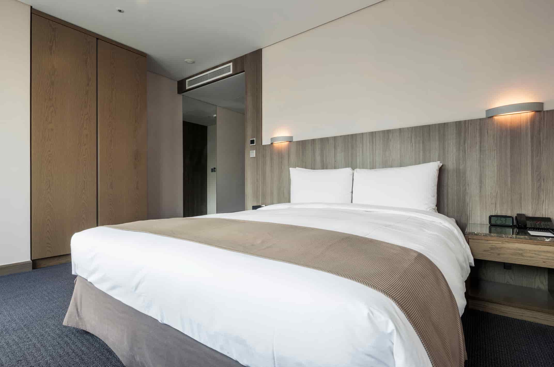 Guest room furniture manufacturer in Turkey showing modern hotel bedroom with custom bed, headboard, wardrobe and bedside unit.