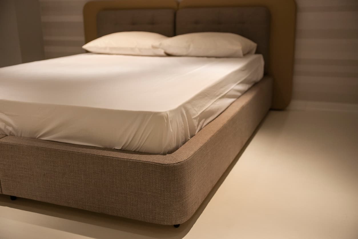 Upholstered hotel bed base with integrated headboard, designed for durable hospitality and contract projects.