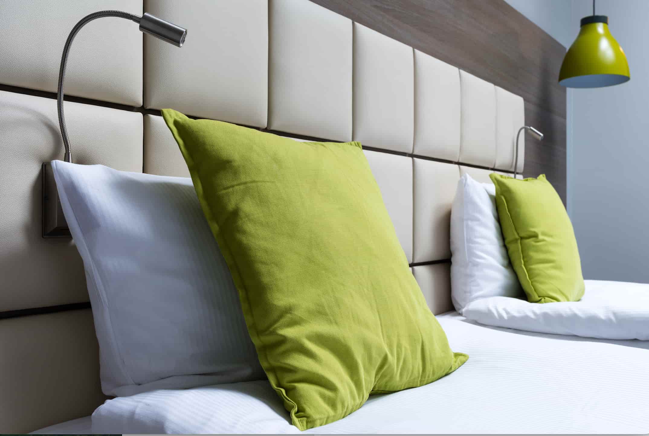 Hotel headboard with upholstered panel design, integrated reading lights and modern finish for hotel bedrooms.